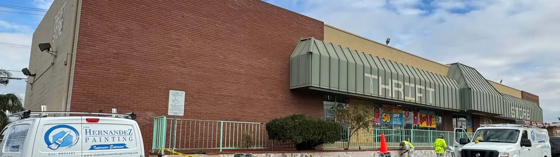 Commercial building with faded, chipped tan paint in need of preparation and painting.