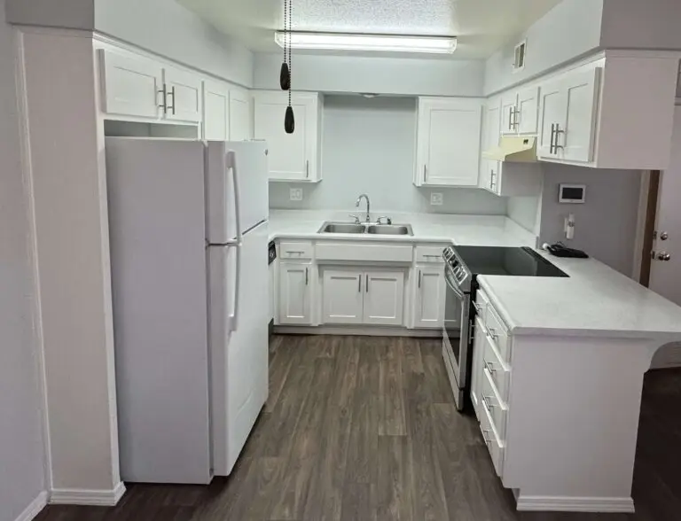 Newly painted kitchen cabinets with glossy bright white finish.