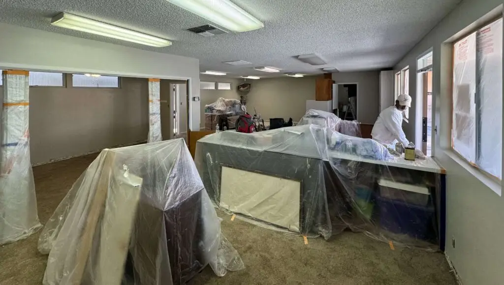 Interior Bakersfield, CA preschool with everything covered for wall painting preparation.