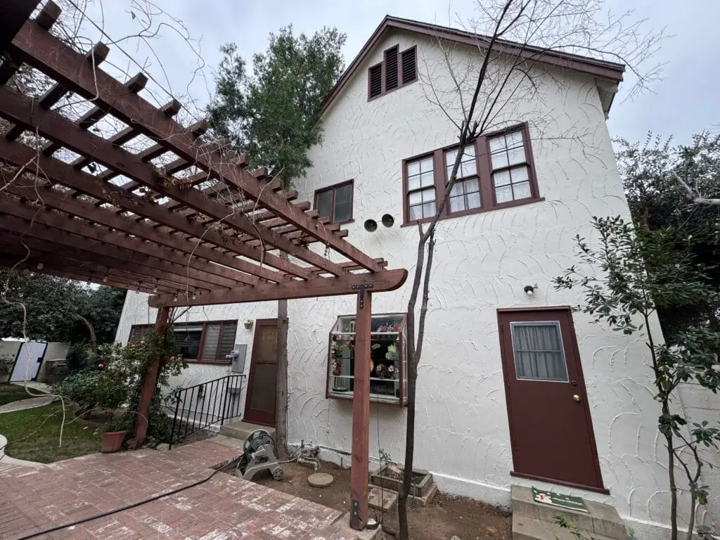 Exterior Home Painting with white stucco, brown fascia boards and a painted brown front door completed by local Bakersfield, CA painter John Hernandez Painting
