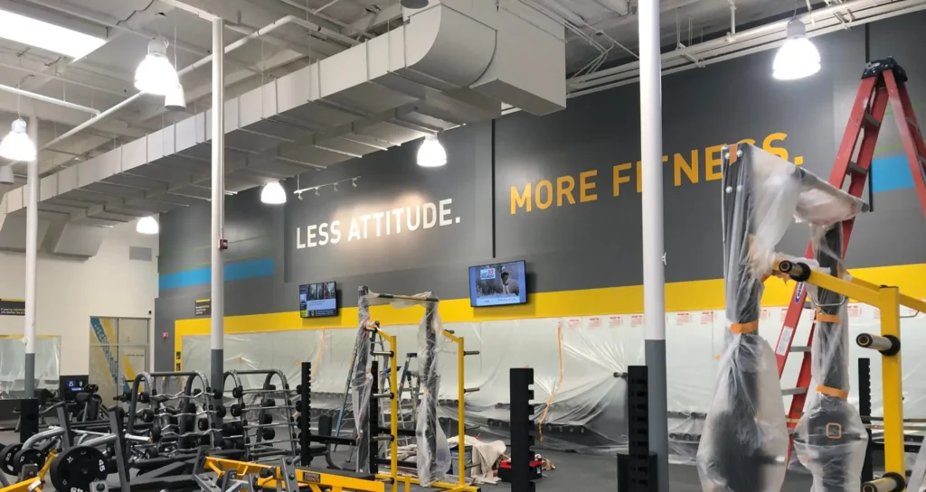 Interior commercial building painting of gym walls and striping.